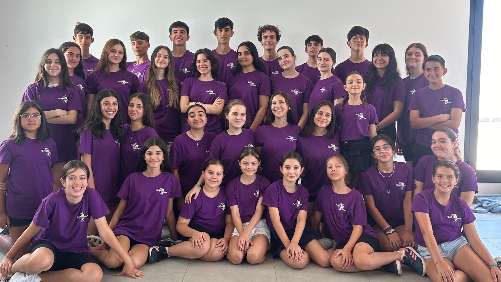 Alumnado del Aula de Teatro Musical del Liceo de Moguer posa en grupo con camisetas moradas.